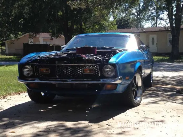 The blue 1972 Mustang Mach 1 fastback in the driveway with the hood open
